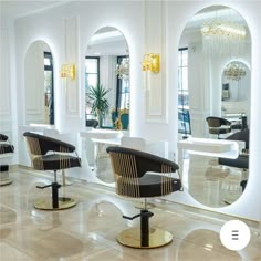 the interior of a salon with chairs and mirrors