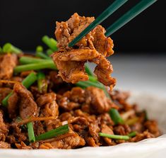 a close up of a plate of food with chopsticks sticking out of it