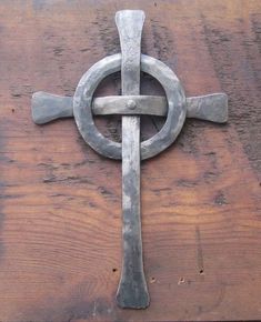 an old metal cross on top of a wooden table