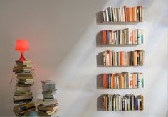 there is a lamp that is next to some books on the wall and in front of it