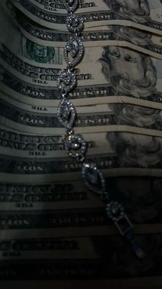 a bunch of money that is laying on top of each other with chains attached to it