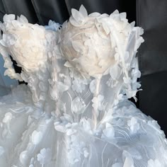 the back of a wedding dress with flowers on it