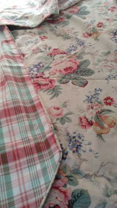 two ties laying next to each other on a floral print bed sheet and pillowcase