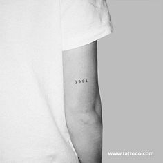 a person with a small tattoo on their left arm that reads 10101 in black ink