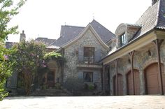 a large stone house with two garages