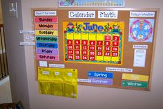 a bulletin board with calendars on it next to a stair case in a child's room