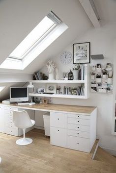 an attic bedroom with white furniture and skylights on the roof, along with bookshelves