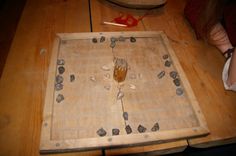 a wooden board with rocks on it and a spoon sitting on top of the board