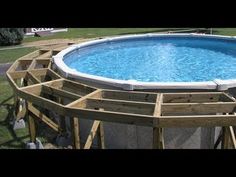 an above ground swimming pool surrounded by wooden boards