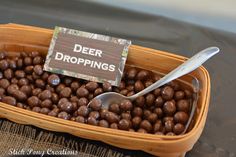 a wooden basket filled with chocolate balls and a sign that says deer droppings on it