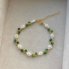 a green and white beaded bracelet with pearls, crystals and beads on a gold plated chain