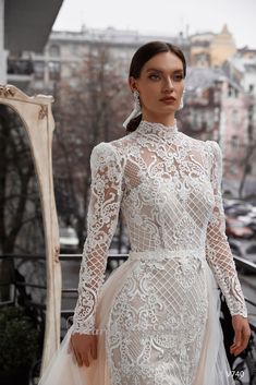 a woman in a white dress standing on a balcony