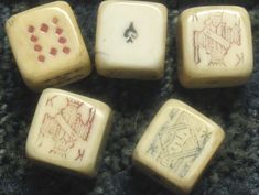 four dices with different designs on them sitting on the ground next to a ruler