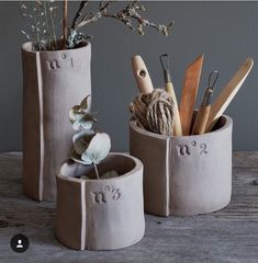 three vases with plants in them sitting on a table