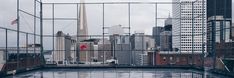 an empty parking lot in the middle of a city with tall buildings and skyscrapers