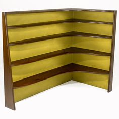 an open book shelf with yellow paint on the top and bottom half, against a white background