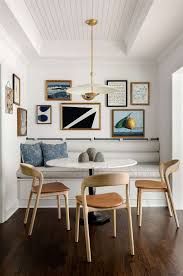 a dining room table with chairs and pictures on the wall