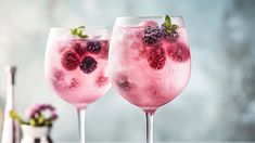 two wine glasses filled with ice and berries