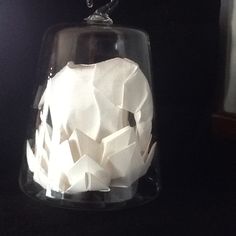 a glass bell jar filled with white tissue paper