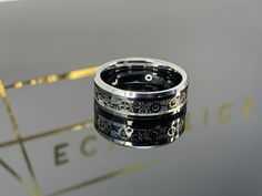 two wedding bands with black and white designs on them, sitting on top of a table