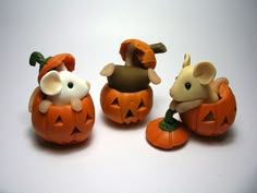 three small pumpkins with mice in them