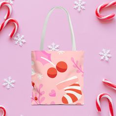 a pink bag with candy canes and snowflakes around it on a pink background