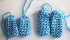 three crocheted baby mittens are sitting on a table