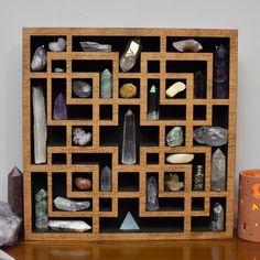 a wooden shelf filled with lots of different types of rocks and crystals on top of a table