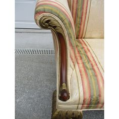 a striped couch sitting on top of a floor next to a white door with a wooden handle