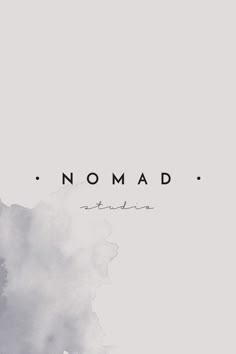 the words nomad written in black and white ink on a gray background with watercolor stains