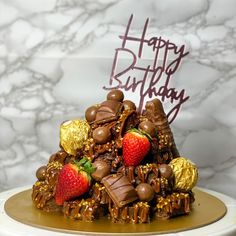 a birthday cake with chocolate and strawberries on top