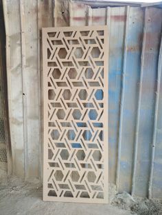 a large white wooden screen sitting on top of a cement floor next to a building