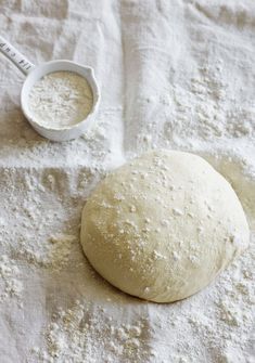 a ball of dough next to a measuring cup