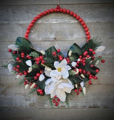 a wreath with white flowers and red berries