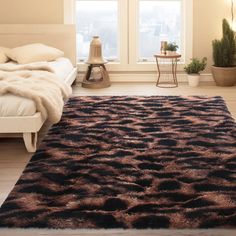 a bed room with a large rug on the floor next to a window and potted plants