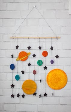 a solar system made out of glass and wood with stars hanging from the wall next to it