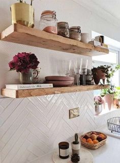 two wooden shelves filled with pots and pans on top of a white tiled kitchen counter