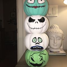 three pumpkins decorated to look like cartoon characters stacked on top of each other in front of a white busturine