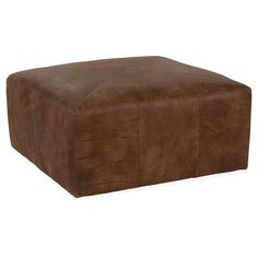 a brown leather ottoman sitting on top of a white floor