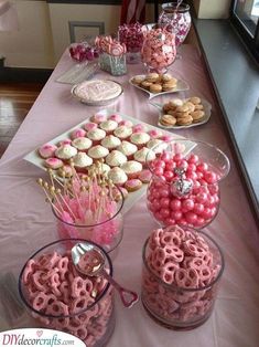 the table is set up with cupcakes and candy