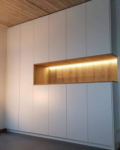 an empty room with some lights on the wall and shelves above it that are made out of plywood