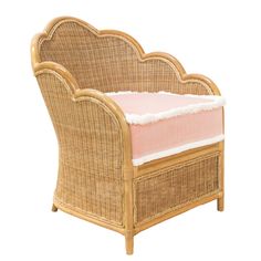 a wicker chair with a pink blanket on it's back and seat cushion