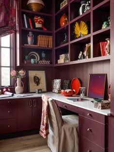 an office with purple bookcases and lots of books on the shelves in it