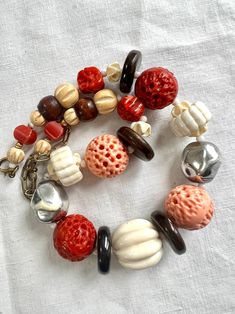 "Beautiful handmade artisan pieces of old French jewellery. Used multi material including carved galalith beads with 4 brown ceramic spacers, white little plastic spacers and some middle size wood beads. The galalith beads comes in cream white, angle sink pink and coral red colour. Caved, drilled and sculpted to very unique pieces. They have the pink and red coral look.  Vintage Art Deco Early Cast Plastic Faux Coral & Ivory Carve Bead Necklace  Beautifully old hand carved jewellery. A true collector's piece. Necklace length: 40cm.  There is 10cm extension chain. Strung on fish wire.  It has its original bronze spring ring clasp. In good vintage condition. There is a bit wearing on the two silver metal like beads, but can see the traces of time as  a 3D effect as well. No missing beads.  S Large Vintage Beads For Jewelry Making, Retro Wooden Beads Jewelry, Vintage Style Wooden Beads For Jewelry Making, Retro Wooden Bead Jewelry, Retro Wooden Round Bead Jewelry, Vintage Jewelry With Wooden Round Beads, Vintage Necklaces With Wooden Beads, Vintage Red Wooden Beads, Handmade Retro Bakelite Jewelry