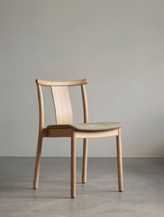 a wooden chair sitting on top of a cement floor