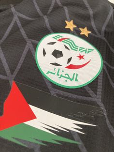 a soccer jersey with the flag of iraq on it's chest and two stars