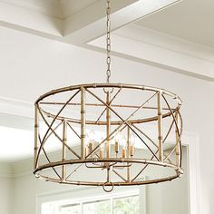 a chandelier hanging from the ceiling in a room with white walls and windows