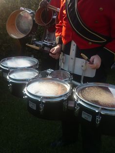 drummers are playing drums on the grass