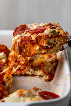 a slice of deep dish pizza being lifted from a casserole dish with melted cheese and pepperoni