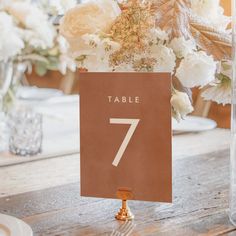 a table number on a wooden table with white flowers